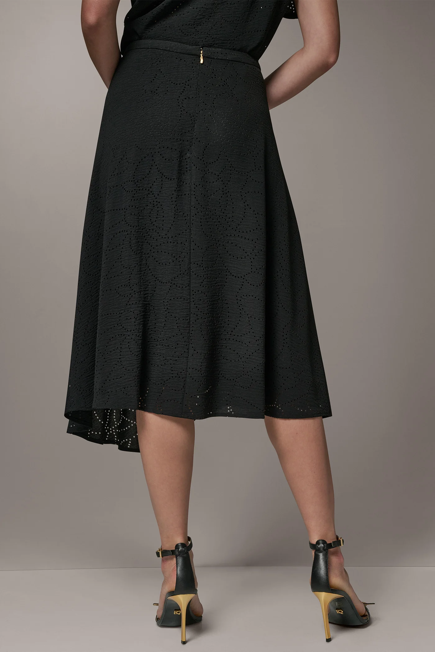 Black laser-cut A-line midi skirt with leaf motifs, an asymmetric hem and a back zipper