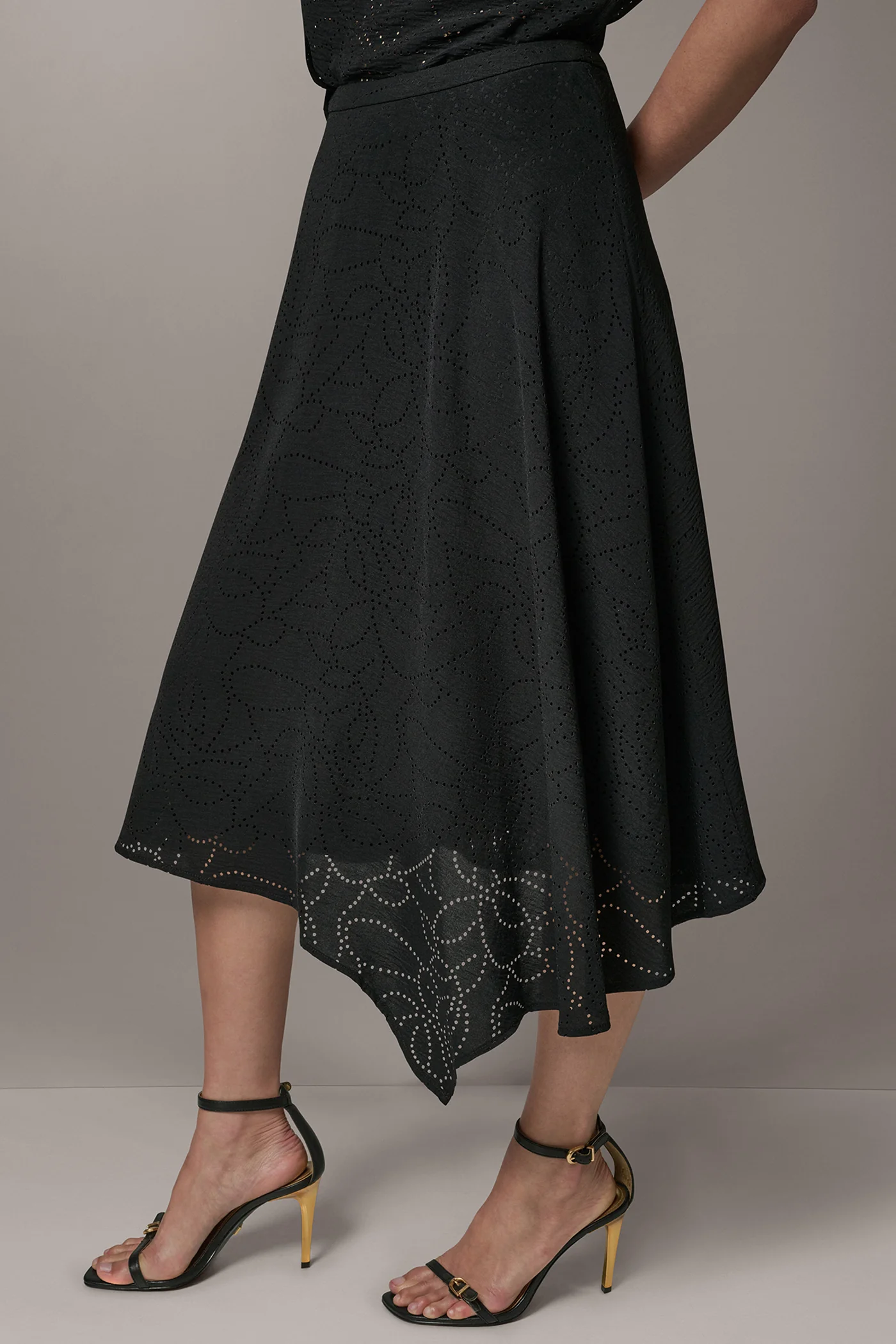 Black laser-cut A-line midi skirt with leaf motifs, an asymmetric hem and a back zipper