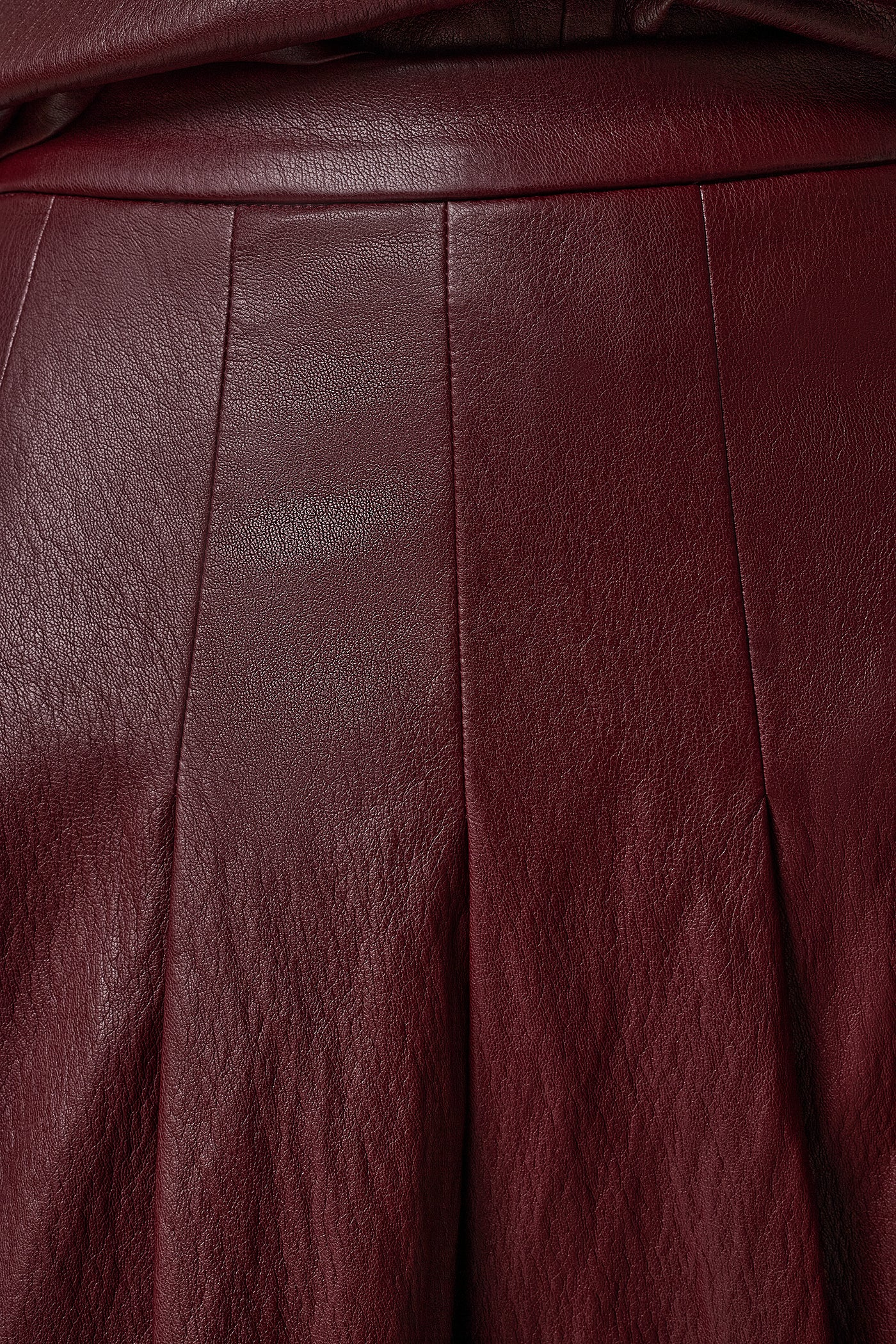 Burgundy faux leather midi skirt with stitched-down pleats and a fitted waistband