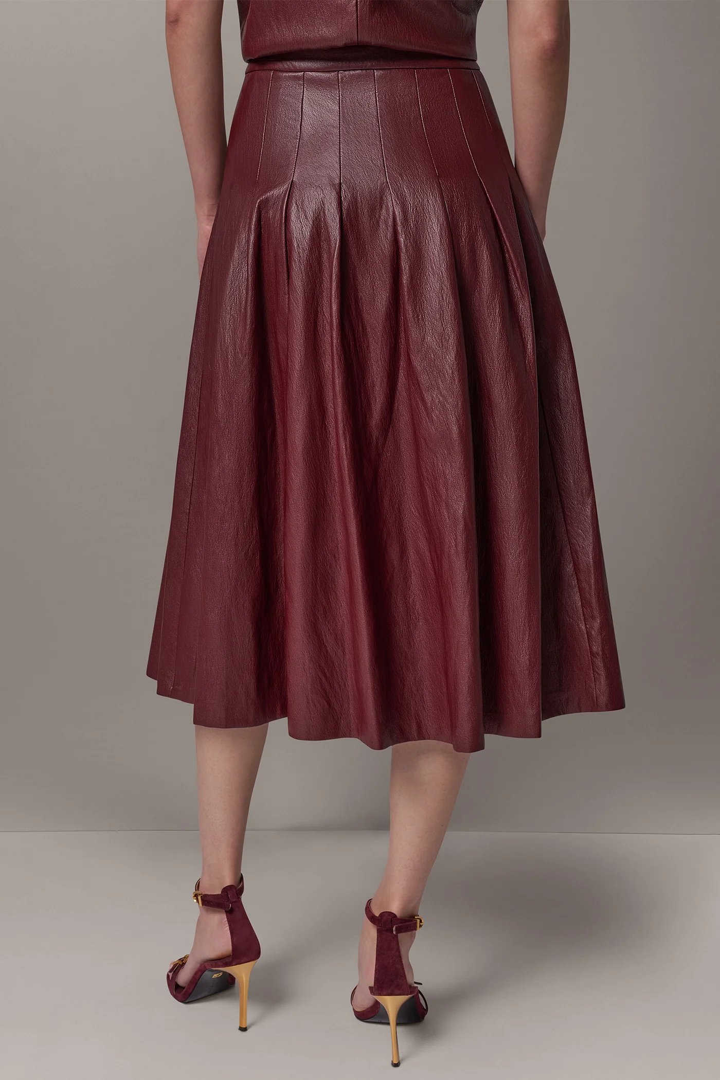 Burgundy faux leather midi skirt with stitched-down pleats and a fitted waistband